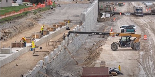 Construction of 9 mile Retaining Wall and I-75 roadway showing machinery and workers